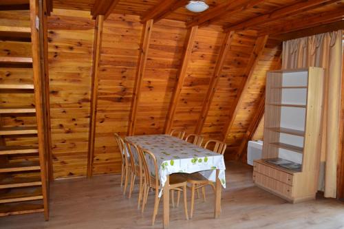 una mesa y sillas en una habitación con paredes de madera en Nowa Holandia en Sieraków