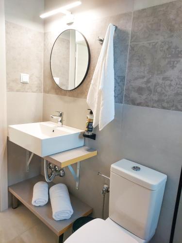 a bathroom with a sink and a toilet and a mirror at Naiades Urban Thassos in Limenas