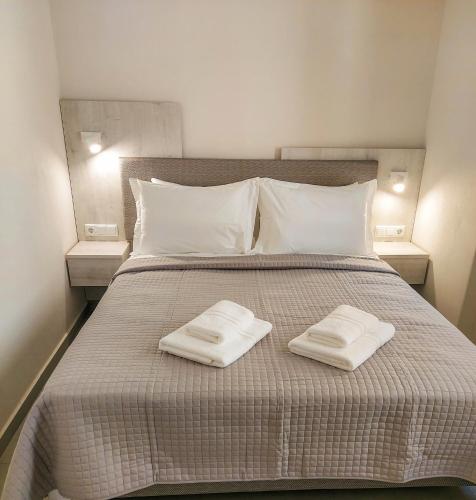 a bed with two white towels on top of it at Naiades Urban Thassos in Limenas