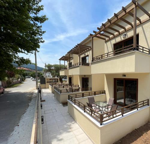 un bâtiment avec des tables et des chaises dans une rue dans l'établissement Naiades Urban Thassos, à Thasos