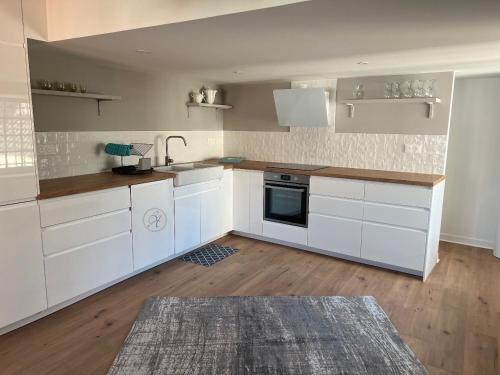 une cuisine avec des armoires blanches et un évier dans l'établissement STUDIO Villa vacances, à Le Touquet-Paris-Plage