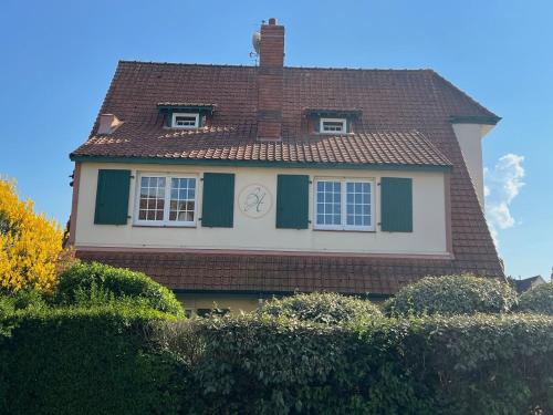 une maison avec une horloge sur son côté dans l'établissement STUDIO Villa vacances, à Le Touquet-Paris-Plage
