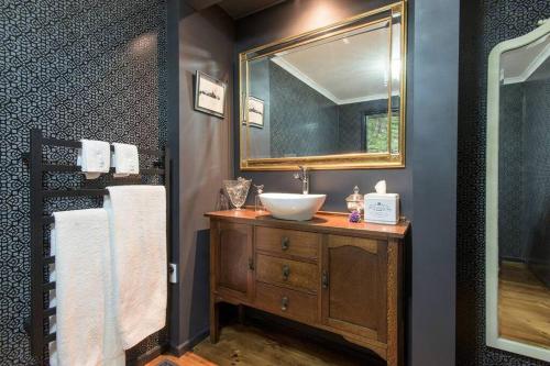 a bathroom with a sink and a mirror at The Beeches Olinda Accommodation in Olinda