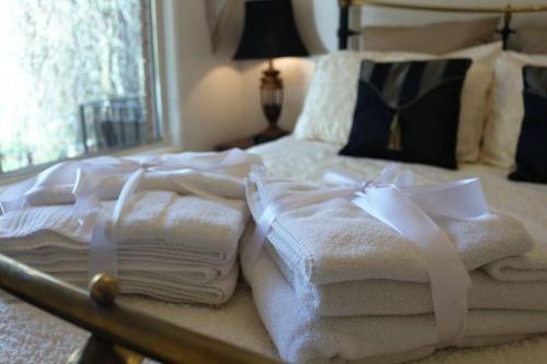 a pile of towels sitting on top of a bed at The Beeches Olinda Accommodation in Olinda