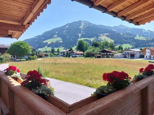 a view of a mountain from a fence with flowers at Bergblick in Westendorf