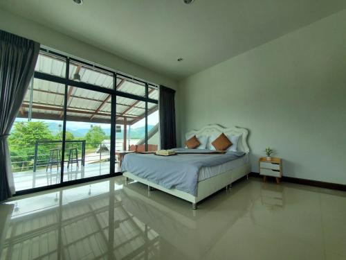 - une chambre avec un lit et une grande fenêtre dans l'établissement สวัสดีปัวโฮมสเตย์ Sawaddee Pua Homestay, à Pua