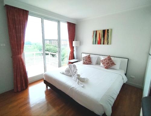 a bedroom with a bed and a large window at Baan Sanploen Huahin Condo By KK in Hua Hin