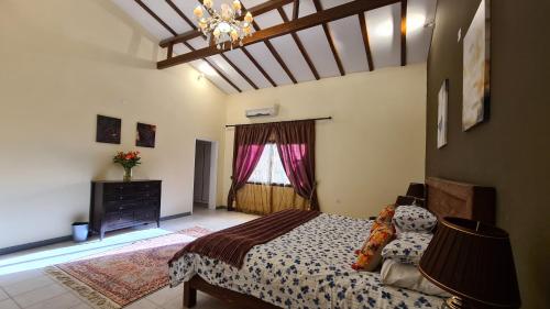 a bedroom with a bed and a dresser and a window at Luxury holiday villas in Bahrain for Families in Bārbār