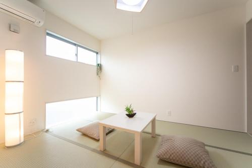 a white room with a table and a potted plant at Nagashima Riverside Resort 2 in Hakuro