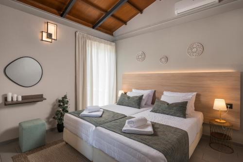 ein Schlafzimmer mit einem großen Bett mit zwei Handtüchern darauf in der Unterkunft Natura Hill Villa III Sunset View in Kounoupidiana