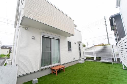 a patio with a bench on the side of a house at Nagashima Riverside Resort 2 in Hakuro