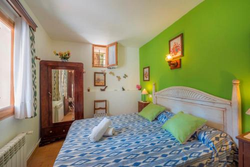 a bedroom with a large bed with green walls at Bonavista (Batle De Bonavista) in Felanitx