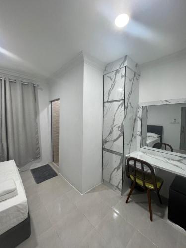 a white room with a bed and a mirror at Demo Inn in Bachok