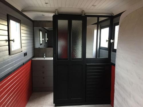 een badkamer met een zwarte deur en een wastafel bij Grande maison de charme avec piscine au coeur des vergers et vignobles in La Roche-de-Glun