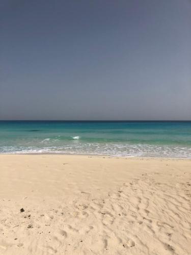 una playa de arena con el océano en el fondo en Amwaj Resort امواج الساحل الشمالى 2 نوم 2 حمام, en El Alamein