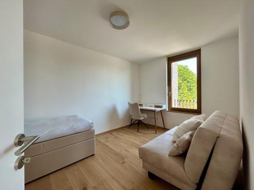 a bedroom with a bed and a desk and a window at Seeparkvilla – Wohlfühlen am See und im Grünen in Bregenz