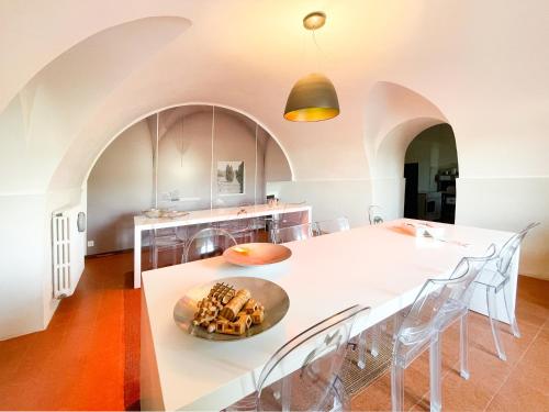 een keuken met een grote witte tafel en stoelen bij La Casa del Poeta Enna - Pergusa in Enna