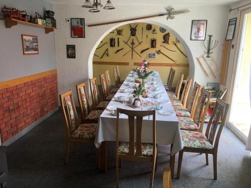 a long dining room with a long table and chairs at Pension U Rytíře in Janov