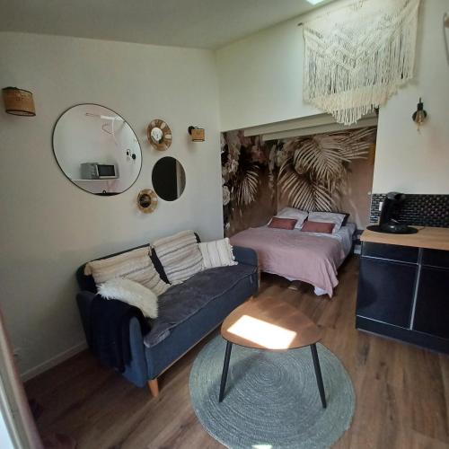 a living room with a couch and a bed at Petit cocon avec terrasse in LʼIsle-sur-la-Sorgue