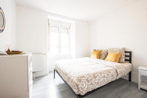 une chambre blanche avec un lit et une fenêtre dans l'établissement Oasis Mulhousien - RDC, wifi, parking, à Mulhouse