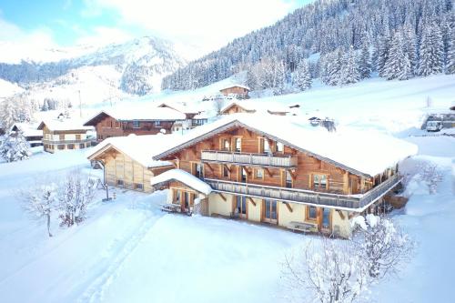 una cabaña de madera en la nieve cubierta de nieve en La Ferme des Georgières "Séjour en tout compris", en Notre-Dame-de-Bellecombe