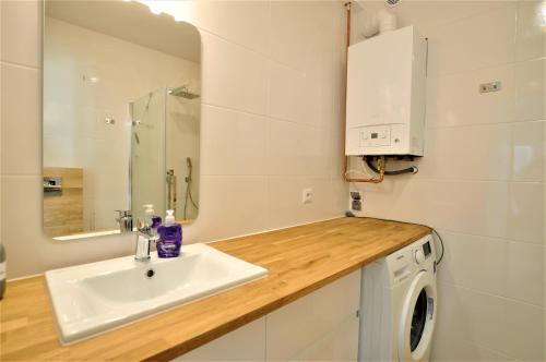 a bathroom with a sink and a washing machine at Apartamenty Wakacyjna Przewłoka in Przewłoka