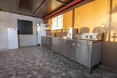 a kitchen with a row of stainless steel appliances at צימר בכפר - סוויטות ובקתות קסומות עם בריכה מחוממת ונוף מהמם in Rama