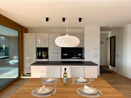 a dining room with a table and a kitchen at Seeparkvilla – Wohlfühlen am See und im Grünen in Bregenz