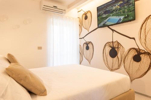 a bedroom with a bed with a tv on the wall at TENUTA FOGLIANI Resort & Natural Spa in Visciano