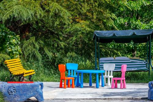 a group of colorful tables and chairs in a park at EcoRest - Likani Palace in Borjomi