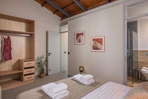 1 Schlafzimmer mit einem großen Bett und einem Badezimmer in der Unterkunft Natura Hill Villa III Sunset View in Kounoupidiana