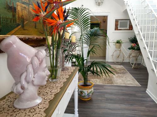 ein Zimmer mit Pflanzen und einem Tisch mit einer Statue in der Unterkunft TAM Vacanze B&B in Cinisi