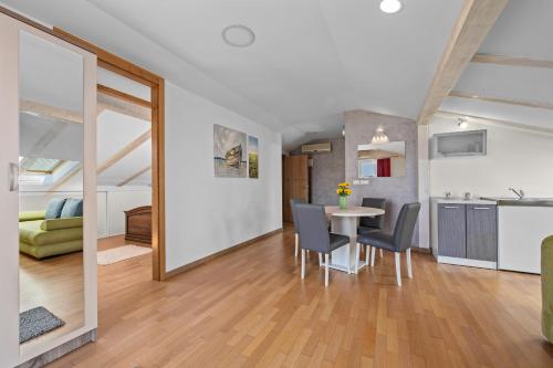 a kitchen and a dining room with a table and chairs at Minerva Hotel in Medulin