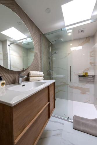 une salle de bain avec un lavabo et une douche avec un miroir dans l'établissement Renovated bijou gem in heart of Cannes, à Cannes