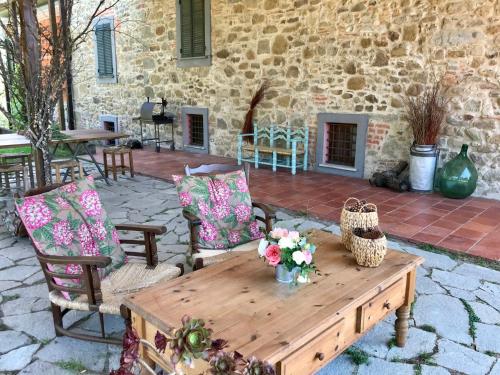 una mesa de madera con flores en el patio en Bed&Breakfast La Madonnina en Marlia