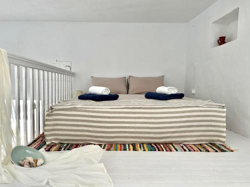 a bedroom with a bed with a striped blanket at Motivo Sea Side in Sifnos