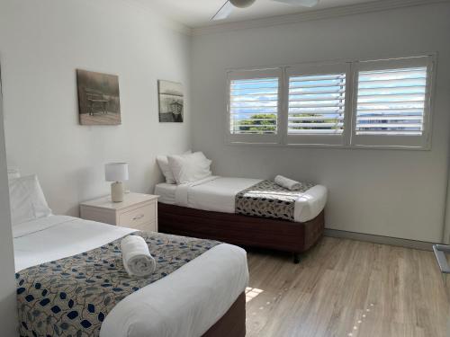a bedroom with two beds and a window at Redvue Holiday Apartments in Redcliffe