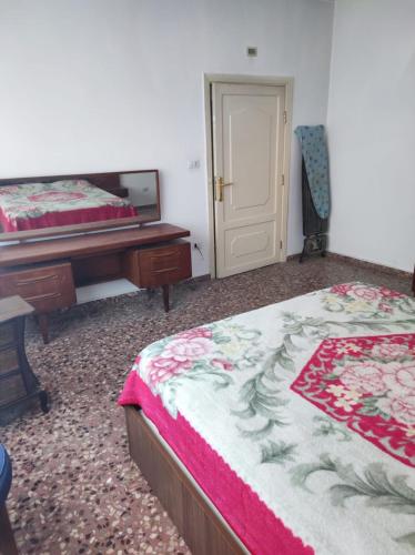 - une chambre avec 2 lits, un bureau et un miroir dans l'établissement Noor Apartment, à Amman