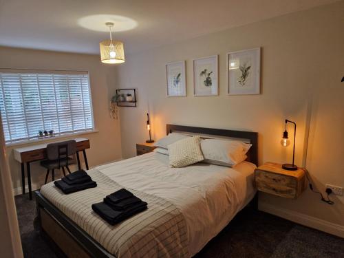 1 dormitorio con cama, escritorio y ventana en Stylish 2 Bedroom Apartment Sleeps 4 Contractors and Corporates Welcome en Birmingham