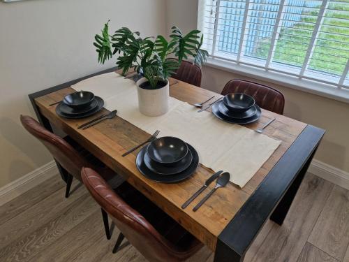 una mesa de madera con tazones y utensilios. en Stylish 2 Bedroom Apartment Sleeps 4 Contractors and Corporates Welcome en Birmingham