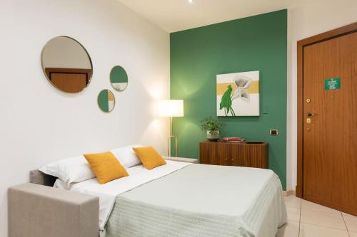 a bedroom with a white bed and a green wall at Saint John Cozy Place in Rome