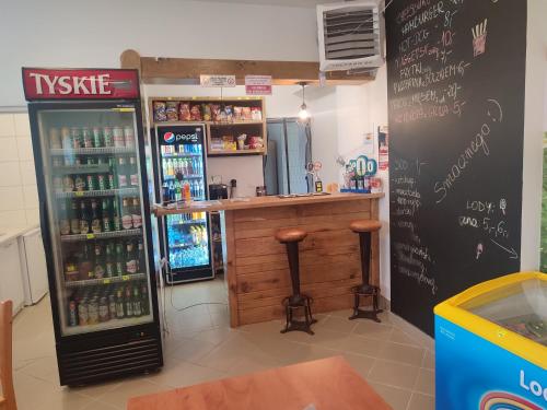 um bar num restaurante com um refrigerador e um balcão em Gościniec IBIS em Czarna Wieś