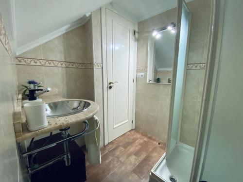 een badkamer met een wastafel en een douche bij Apartamento centro de O Grove in O Grove