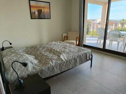 une chambre avec un lit et une vue sur un balcon dans l'établissement LES BALCONS, à Six-Fours-les-Plages