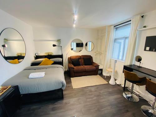 a bedroom with a bed and a chair and a mirror at Studio in central London in London