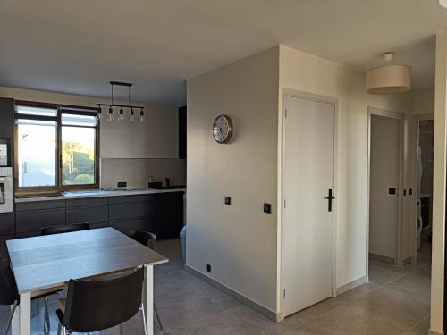 une cuisine et une salle à manger avec une table et une horloge dans l'établissement LES BALCONS, à Six-Fours-les-Plages