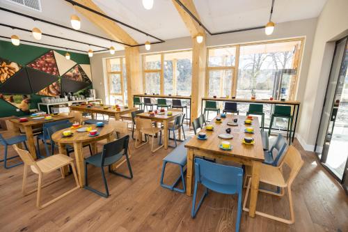 a restaurant with wooden tables and chairs and windows at An Spiris Accommodation at Dundreggan Rewilding Centre in Dundreggan