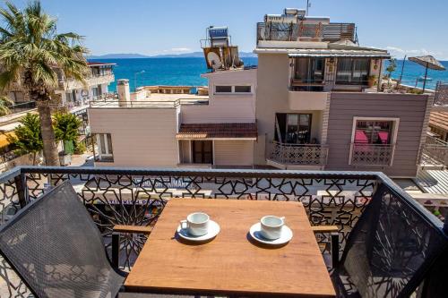 a table on a balcony with a view of the ocean at THE LEA HOTELS & SUITE in Didim