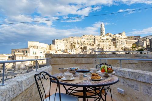einen Tisch auf einem Balkon mit Stadtblick in der Unterkunft Casa Vacanza La Cava nel Barisano Suite Matera in Matera