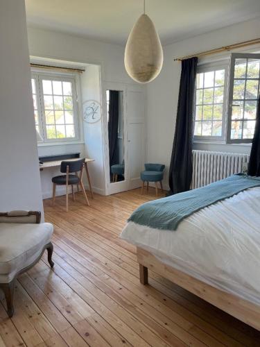 une chambre avec un lit, un bureau et des fenêtres dans l'établissement Villa Vacances, à Le Touquet-Paris-Plage